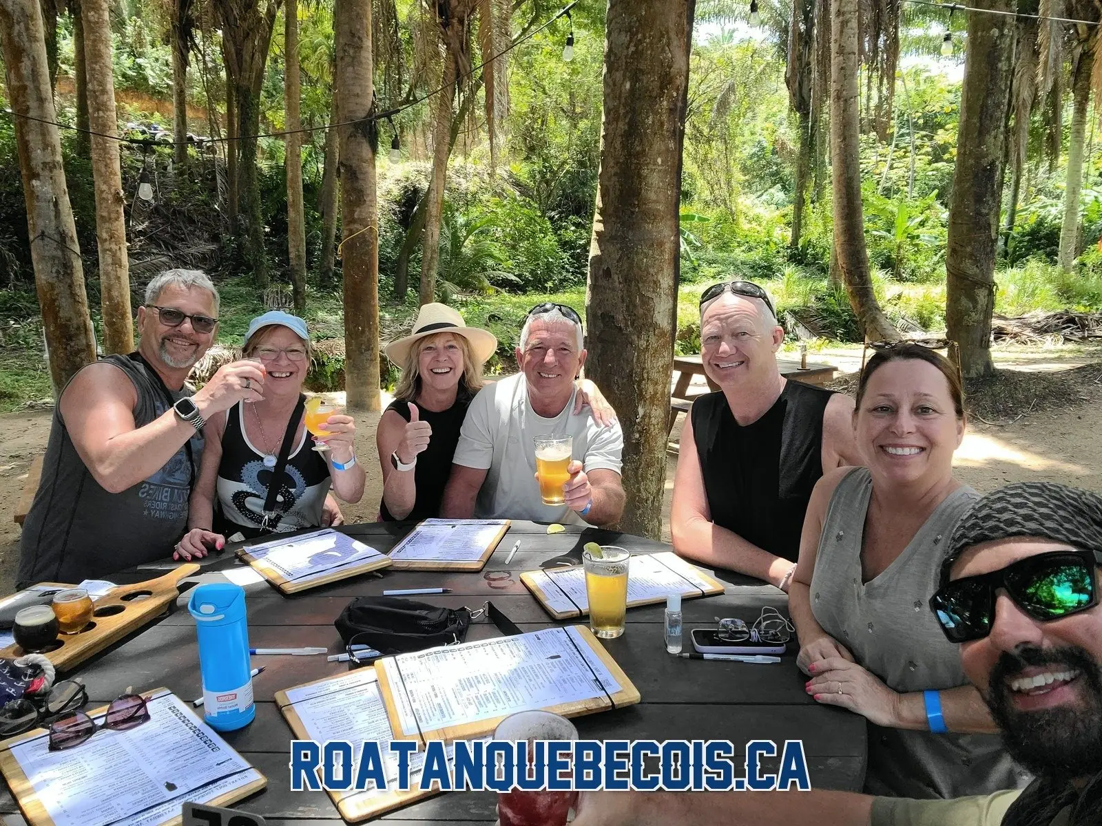 A group of travelers raising a toast at the Roatan Island Brewery with Patrice