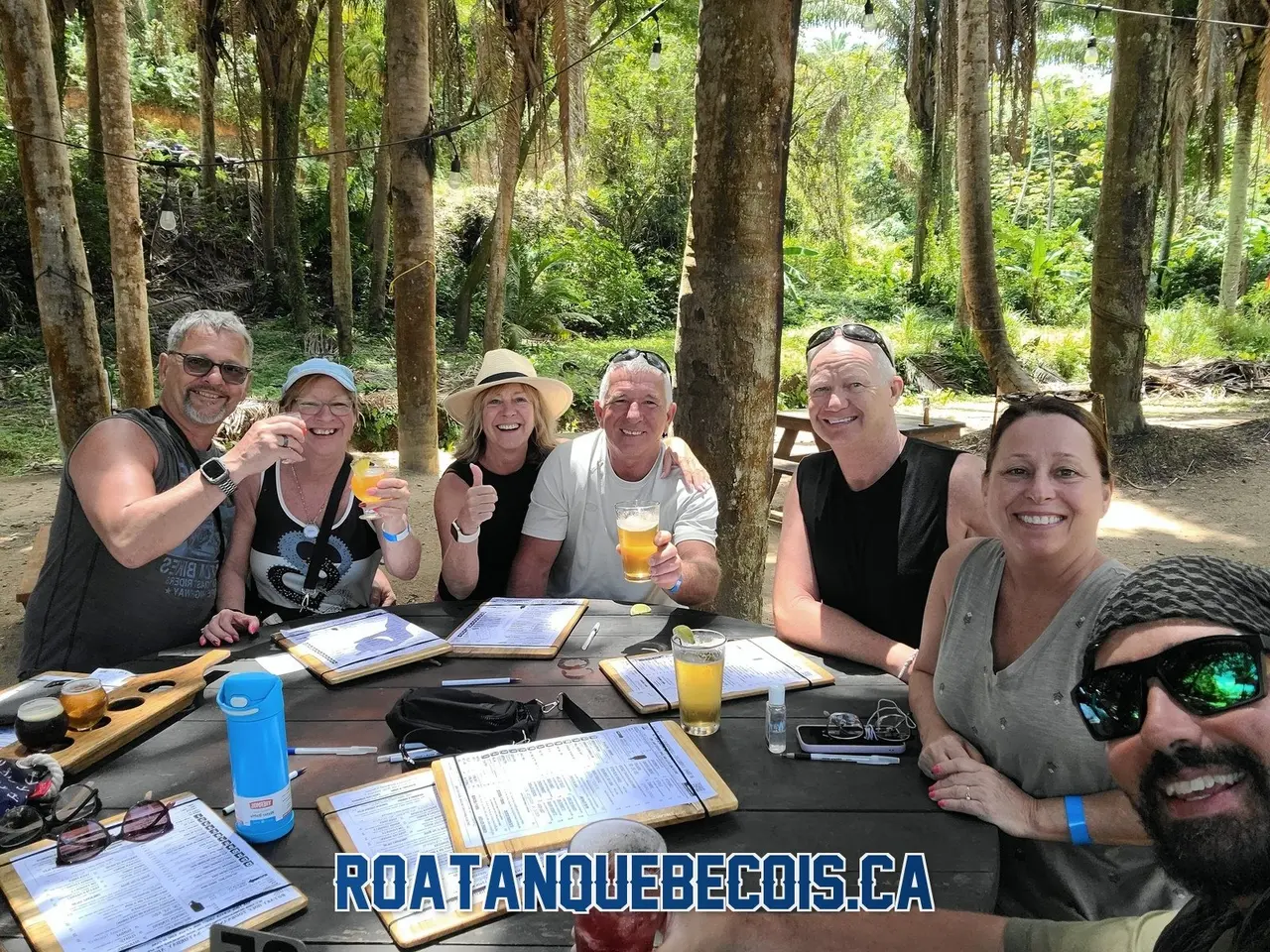A group of travelers raising a toast at the Roatan Island Brewery with Patrice