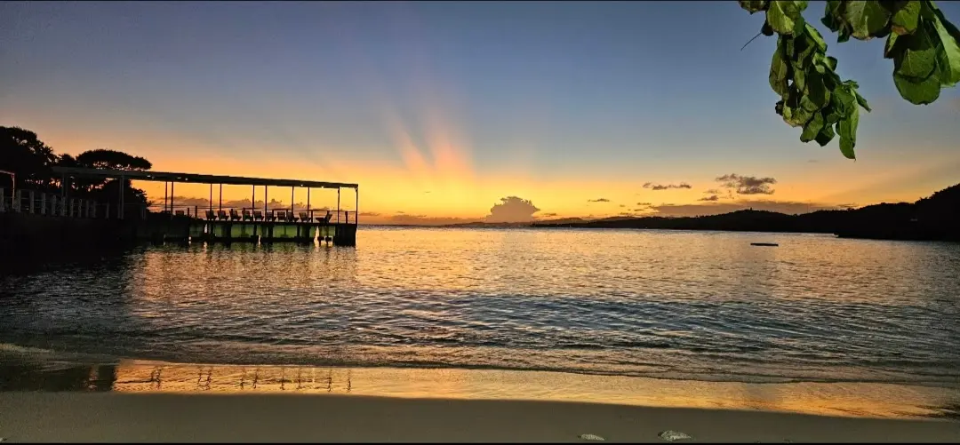 Coucher de soleil flamboyant sur la mer et le ponton du complexe