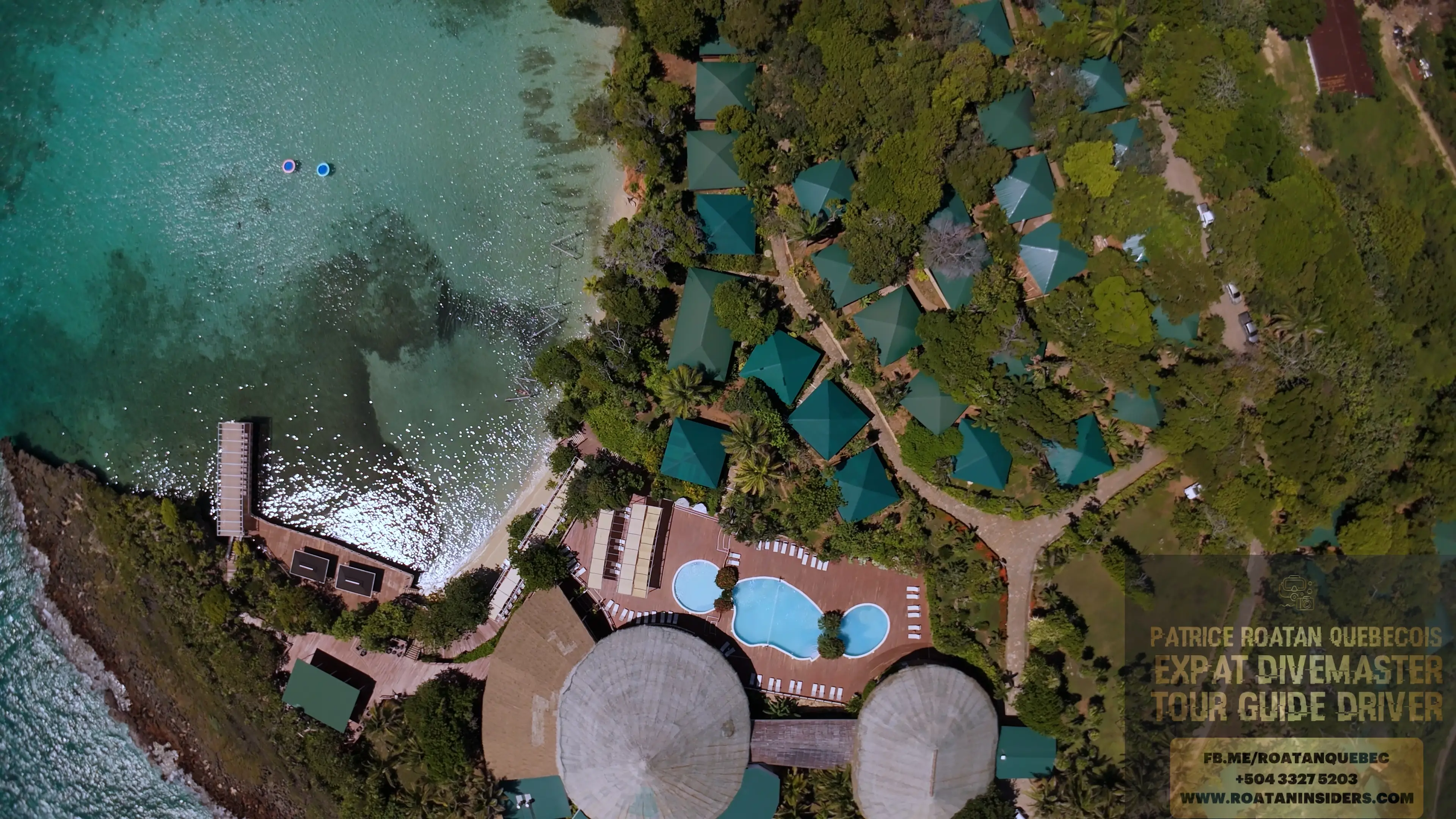 Vue plongeante sur la piscine, les toits coniques en palapa et la crique du resort