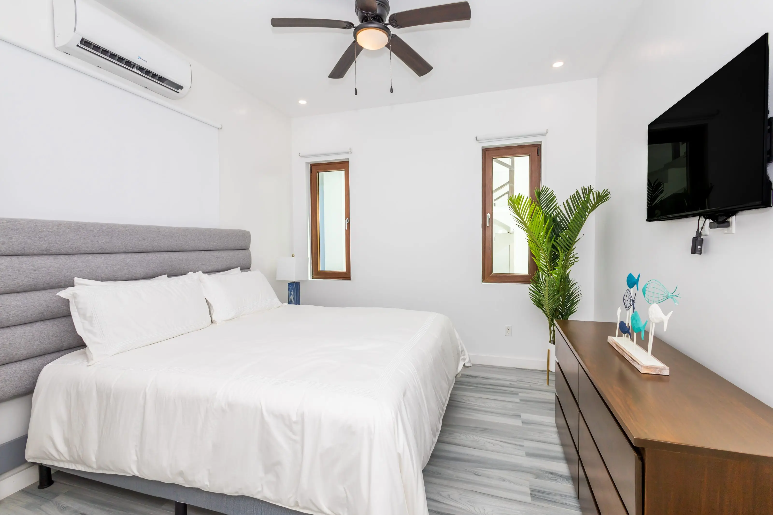 Bedroom with king bed, ceiling fan, wall-mounted air conditioning and television