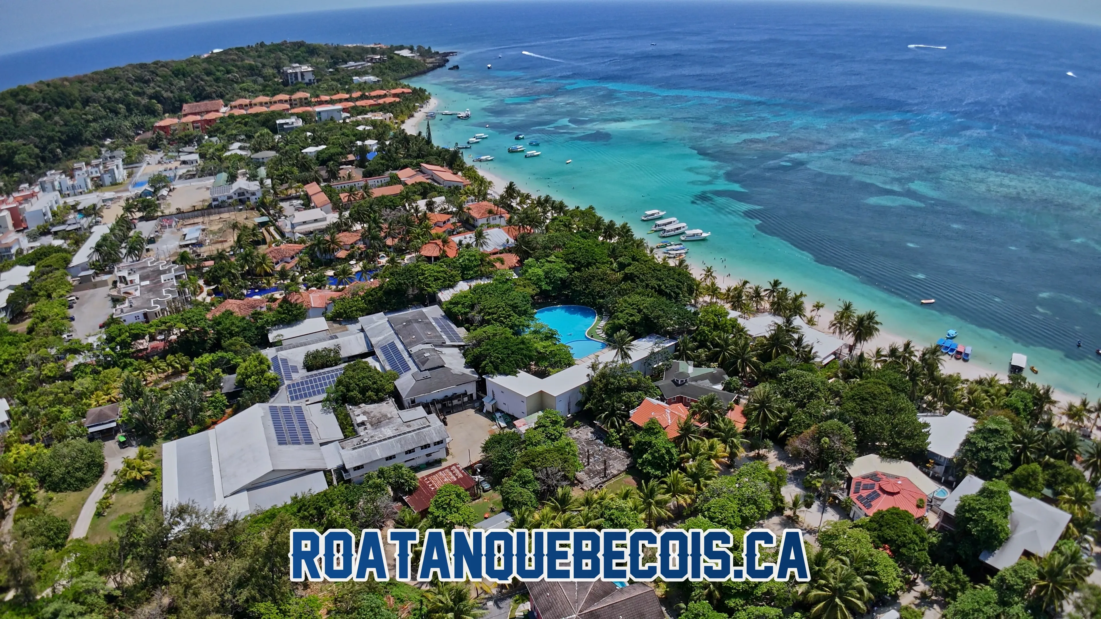 Vue aérienne du Henry Morgan Hotel and Beach Resort et de la plage de West Bay à Roatán, avec la piscine, les resorts voisins et les bateaux sur le récif