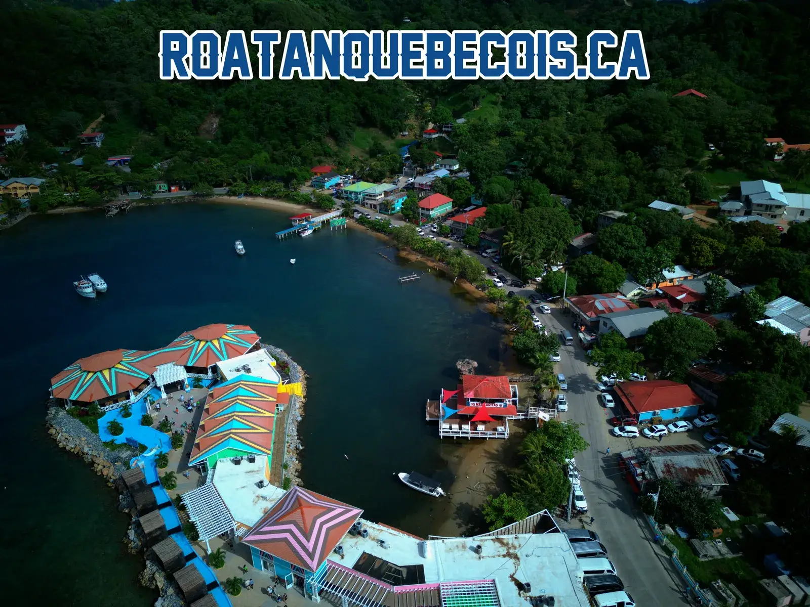 The terminal peninsula at Port of Roatán seen from above, the bay at Coxen Hole and the shoreline road behind it