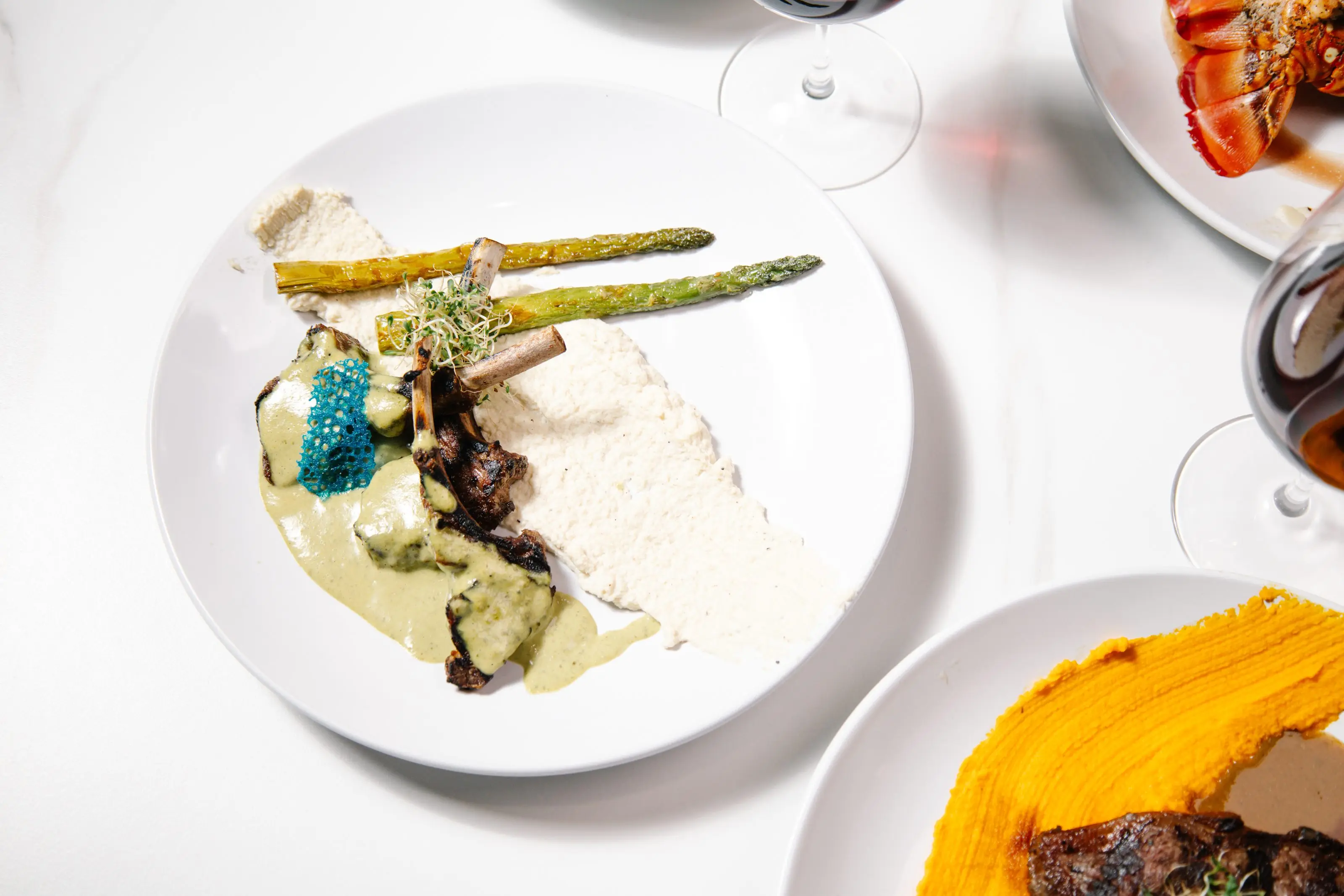 A plate from the Acqua di Mare restaurant: rack of lamb with asparagus, lobster in the background