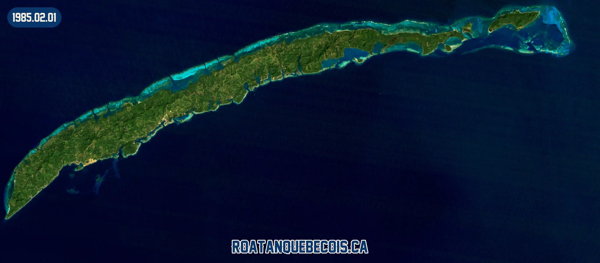 Roatán vue du ciel le 1er février 1985 : l'île entière, son récif et les zones bâties