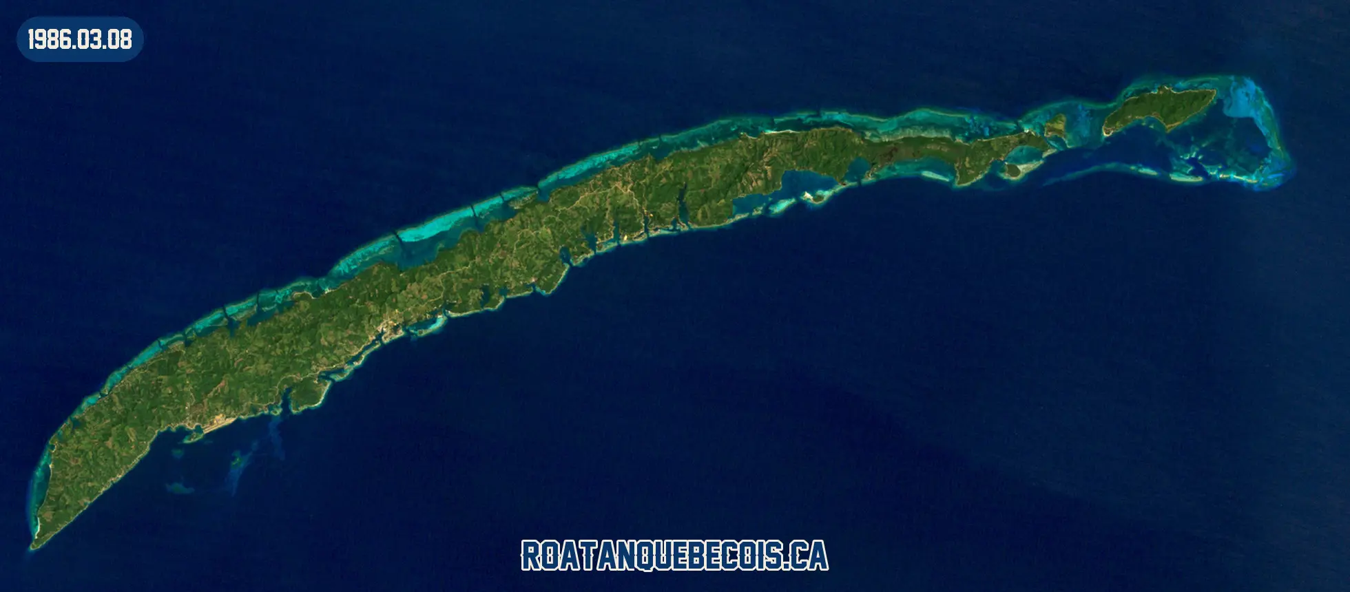 Roatán vue du ciel le 8 mars 1986 : l'île entière, son récif et les zones bâties