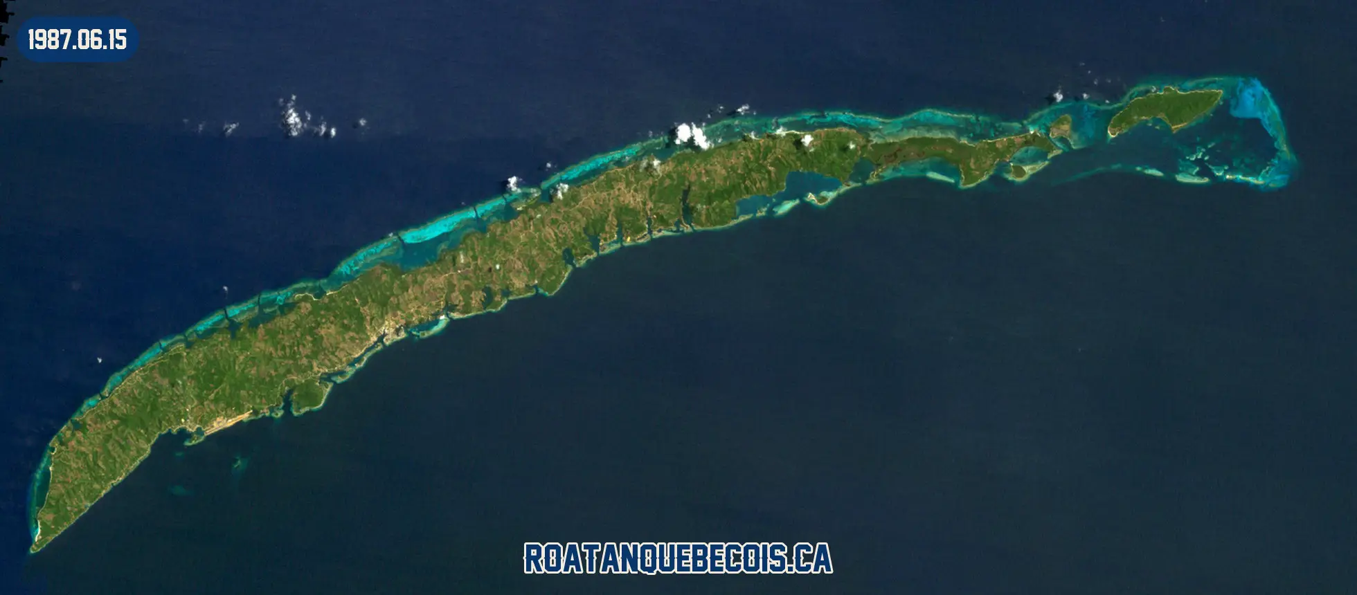 Roatán vue du ciel le 15 juin 1987 : l'île entière, son récif et les zones bâties