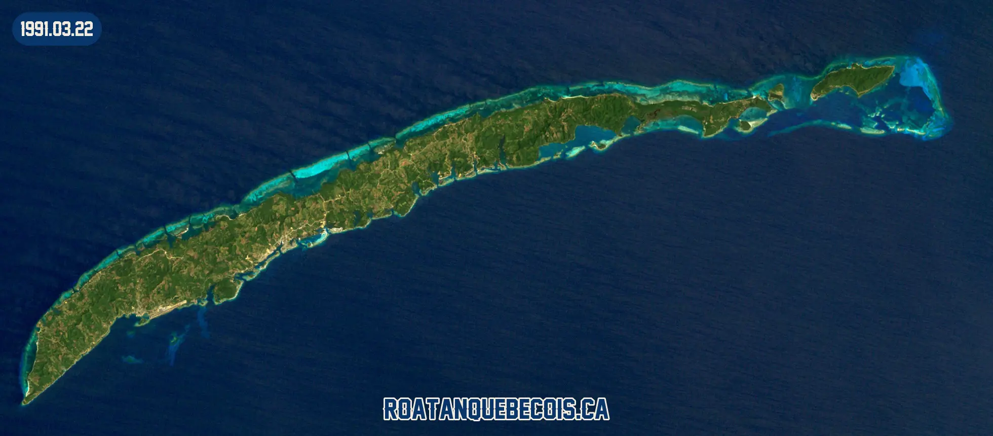 Roatán vue du ciel le 22 mars 1991 : l'île entière, son récif et les zones bâties