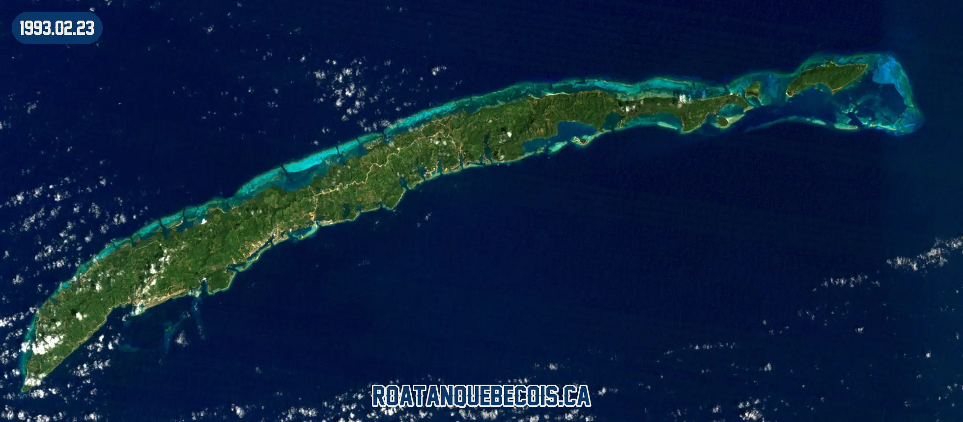 Roatán vue du ciel le 23 février 1993 : l'île entière, son récif et les zones bâties