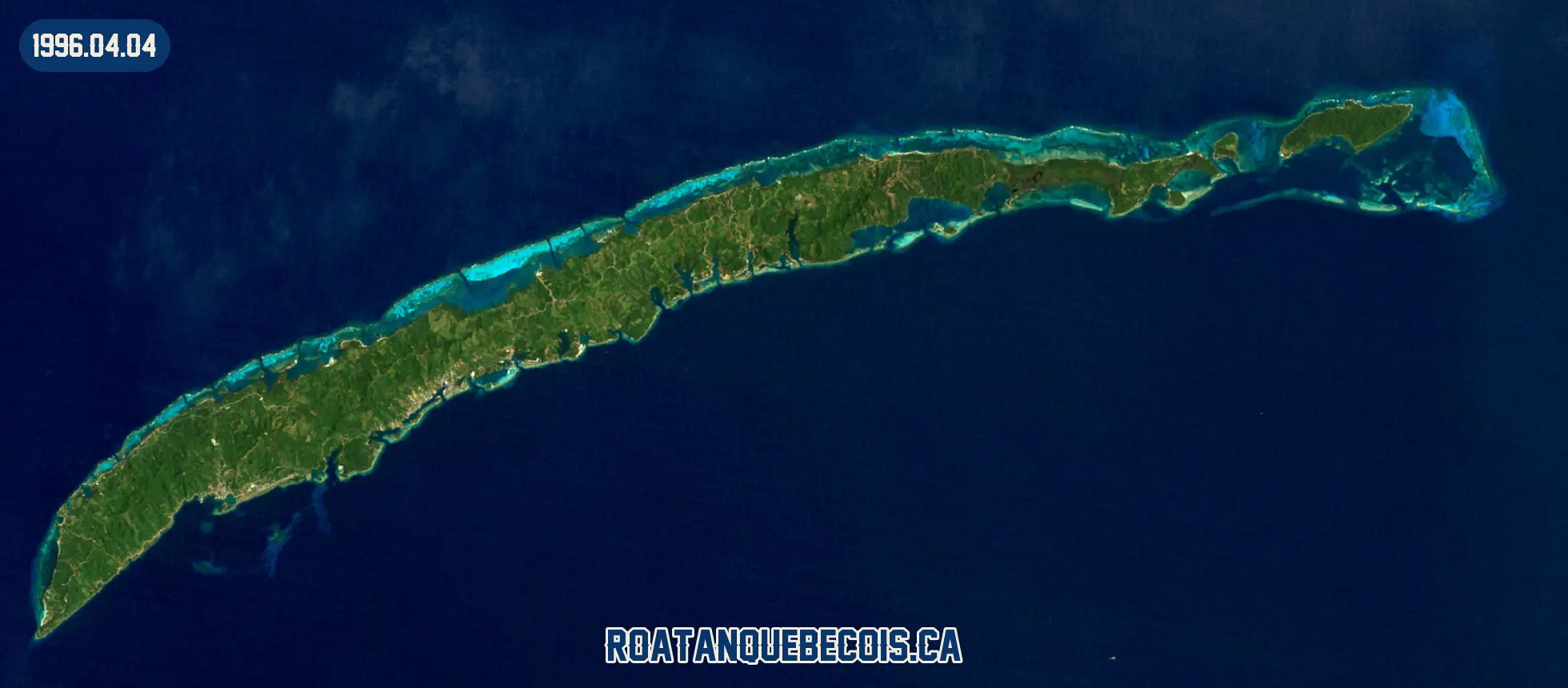 Roatán vue du ciel le 4 avril 1996 : l'île entière, son récif et les zones bâties