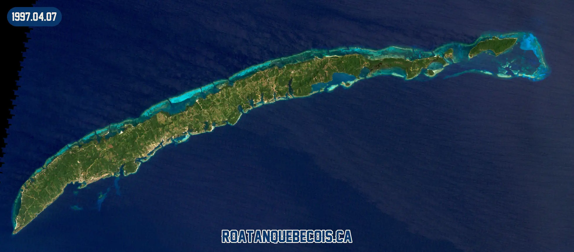 Roatán vue du ciel le 7 avril 1997 : l'île entière, son récif et les zones bâties