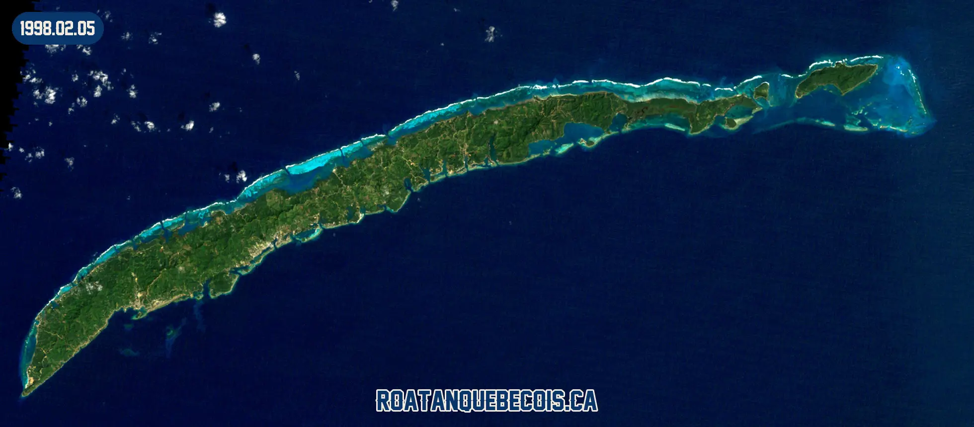 Roatán vue du ciel le 5 février 1998 : l'île entière, son récif et les zones bâties
