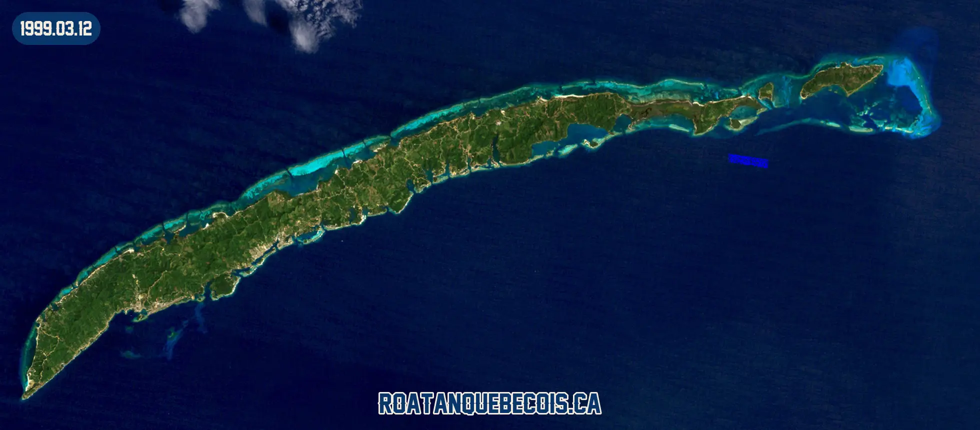 Roatán vue du ciel le 12 mars 1999 : l'île entière, son récif et les zones bâties