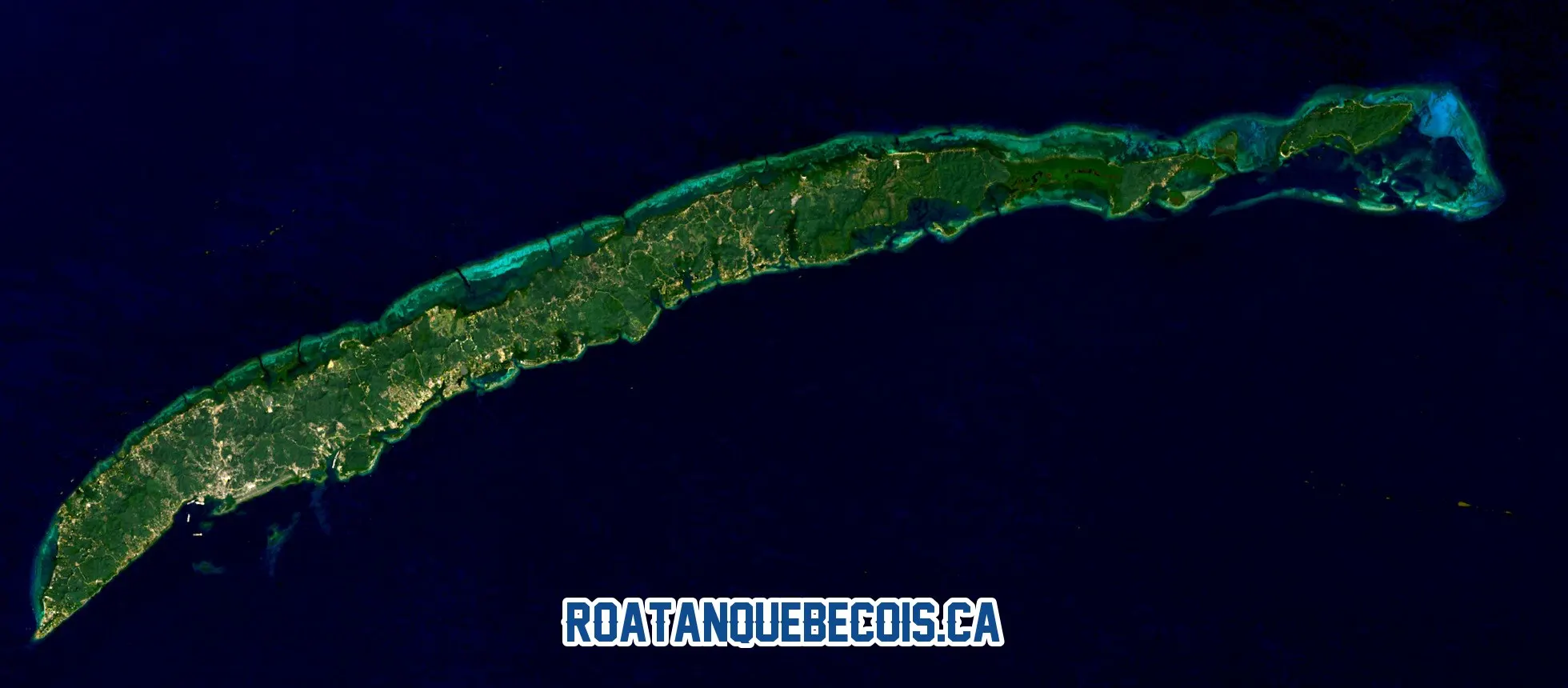 Roatán vue du ciel par le satellite Landsat 8 le 18 février 2026 : l'île entière, son récif turquoise et le bâti pâle le long des côtes