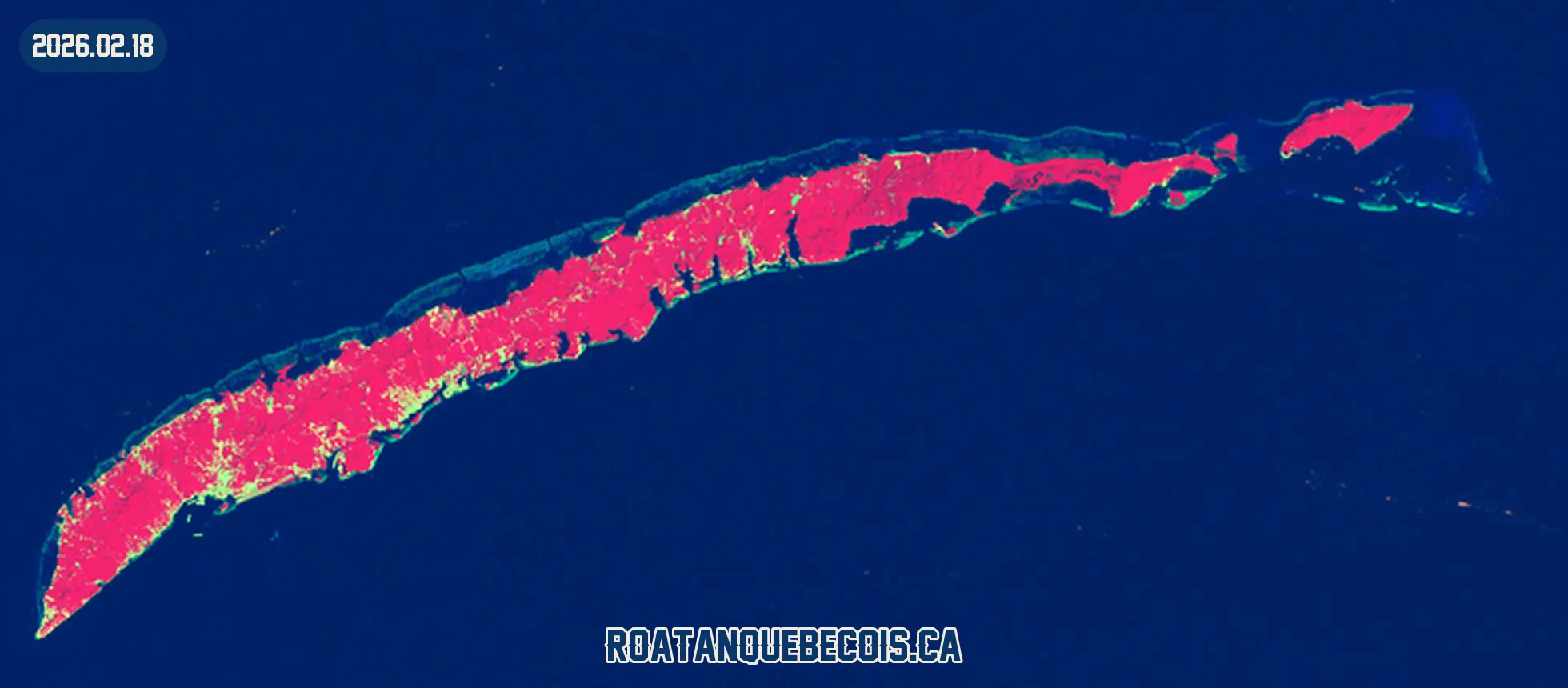 Roatán vue du ciel le 18 février 2026, en fausse couleur infrarouge où la végétation apparaît en rouge : l'île entière, son récif et les zones bâties