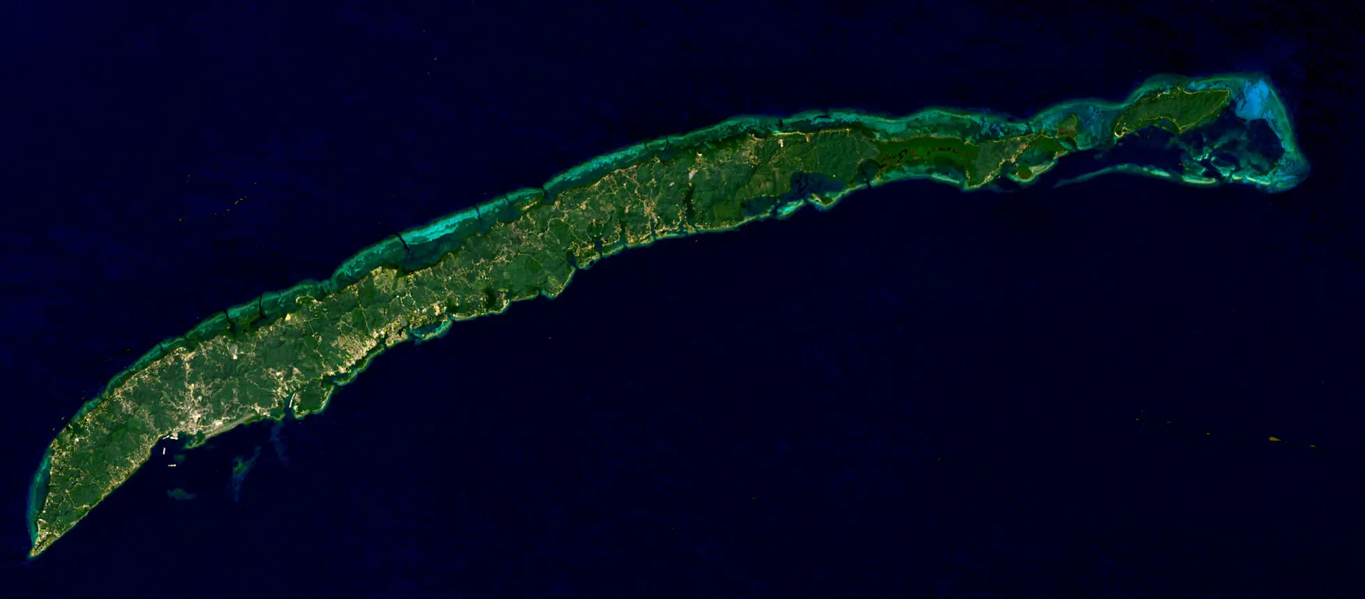 Roatán vue par Landsat 8 le 18 février 2026 : le bâti pâle s'est étendu le long des côtes et vers l'intérieur, dix ans après