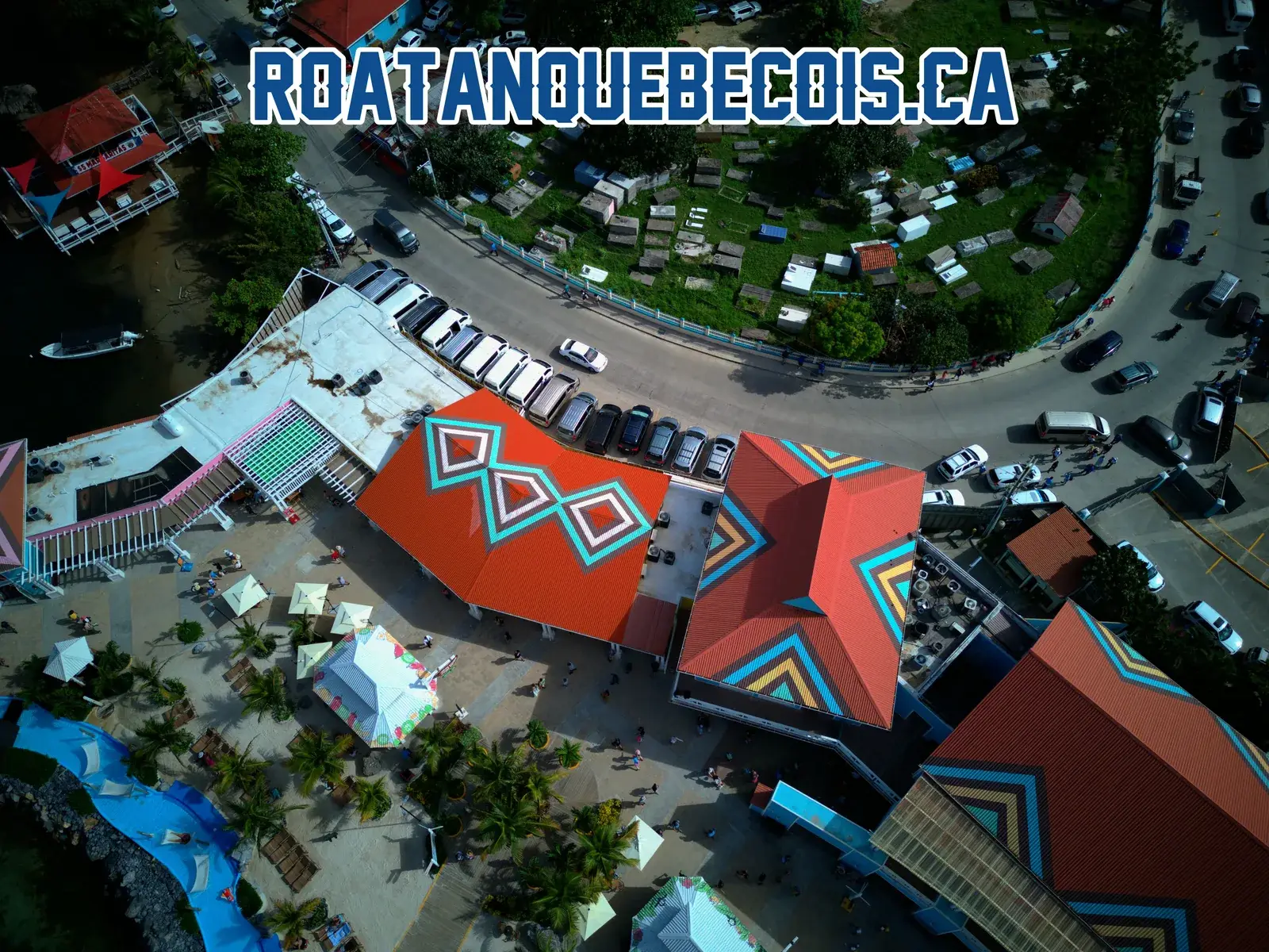 The port road curving past the car park and the terminal roofs at Port of Roatán