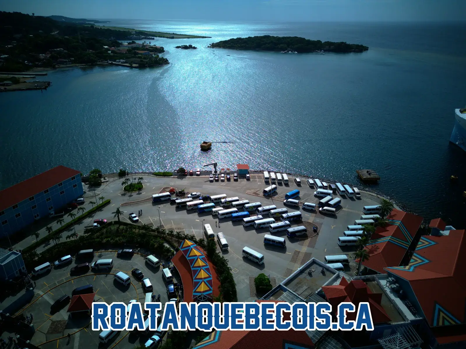 The coach fleet parked at Port of Roatán, the roundabout and the bay with its island beyond